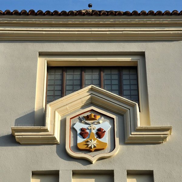 Tortosa.- Església i Col·legi de les Teresianes. Part superior d’una de les dues torres de la façana decorades amb l’escut de la Companyia de Santa Teresa de Jesús (7/2012)