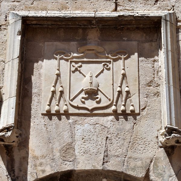 Tortosa.- Palau Episcopal – Escut d’armes del Bisbat de Tortosa esculpit damunt la porta d’accés d’arc de mig punt adovellat (7/2012)