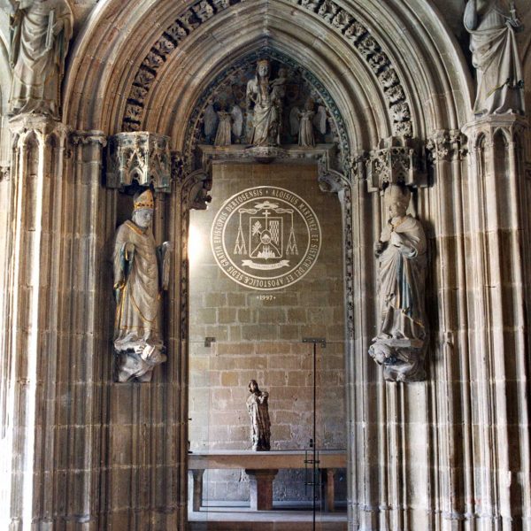 Tortosa.- Palau Episcopal – Porta de la capella d’arc apuntat on trobem la Verge i el nen i dos àngels en el timpà i les imatges de quatre bisbes als costats (2/2003)