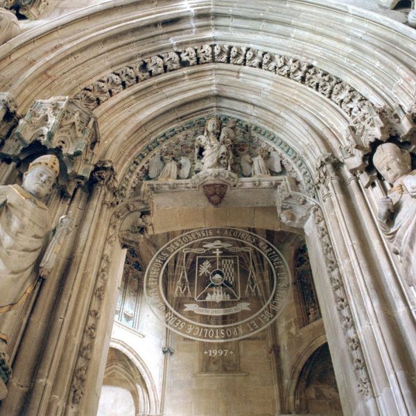 Tortosa.- Palau Episcopal – Porta de la capella d’arc apuntat on trobem la Verge i el nen i dos àngels en el timpà i les imatges de quatre bisbes als costats (2/2003)