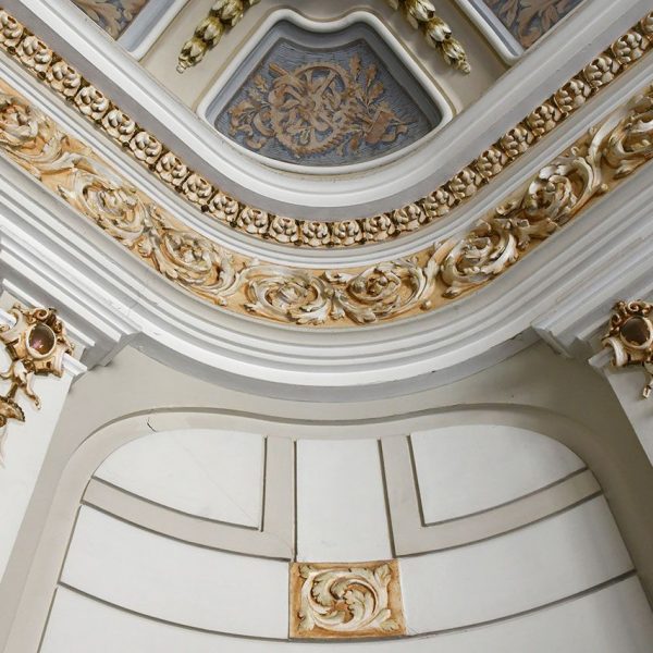 Tortosa.- Casa Brunet de l’any 1913 – Angle raconer arrodonit del vestíbul que mostra el treball en relleu de les pilastres i sanefes daurades del sostre (7/2022)