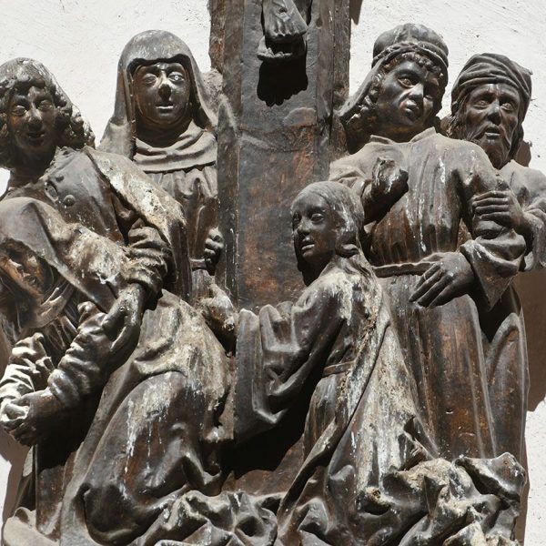 Tortosa.- Portal del Palau, Reproducció del grup escultòric anònim de la crucifixió “Crist de Palau” del S. XV/XVI, a la base té l’escut dels Soldevila (7/2022)