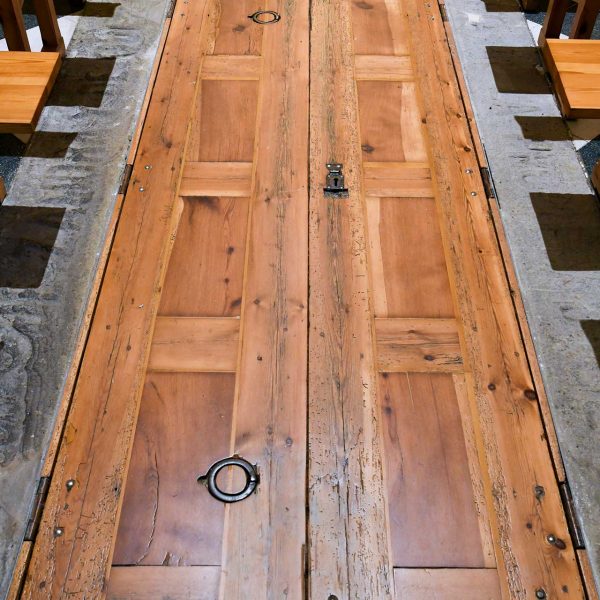 Manresa.- Cova de Sant Ignasi. Peus de Església amb una porta de dos batents que dona accés a una cripta situada en aquest sector (6/2023)