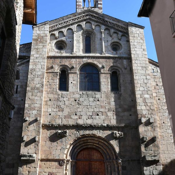La Seu d'Urgell.- Catedral de Santa Maria, S. XII – Façana principal amb la porta flanquejada per dues columnes amb capitells i arquivoltes capçada pel un campanar (2/2025)