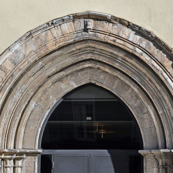 Seu d’Urgell.- Convent gòtic de Sant Domènec, S. XV – Portalada d’arc apuntat amb arquivoltes en degradació sostingudes per columnes amb capitells llisos(2/2025)