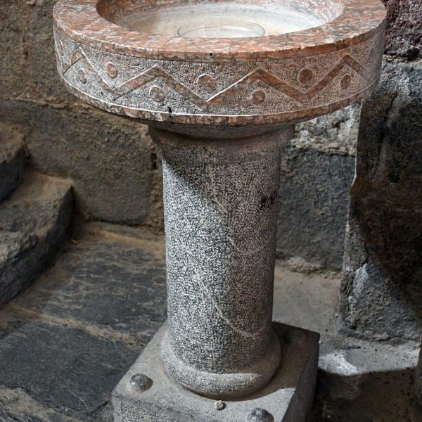 La Seu d'Urgell.- Catedral de Santa Maria, S. XII – Pica beneitera de forma circular decorada amb zigues-zagues i cercles vermellosos sobre un fust cilíndric (2/2025)