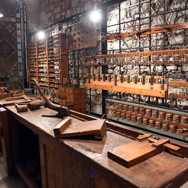 Manresa.- Museu de l’Aigua i del Tèxtil de Manresa situat als antic dipòsits d’aigua – Tauler de fusteria i un conjunt de batans a la dreta del mur i de llançadores de cinteria a l’esquerra (10/2025)