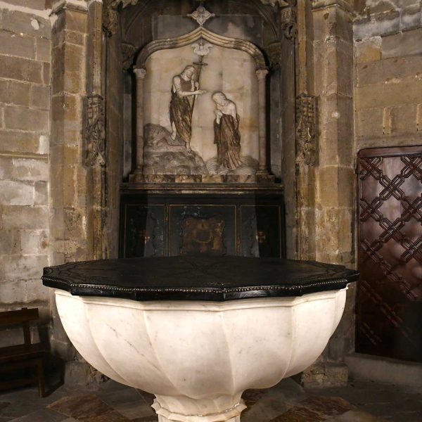Barcelona.- Catedral de la Santa Creu i Santa Eulàlia – Capella baptismal amb la pila de marbre obra d’Onofre Julià el 1433. El relleu del fons amb el baptisme de Jesús es del S. XX (1/2026)