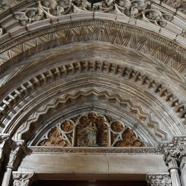 Barcelona.-Catedral de la Sta. Creu i Sta. Eulàlia - Porta d’arquivoltes en gradació del claustre sostingudes per tres columnes per banda. Al timpà hi ha una Verge amb l’infant Jesús (1/2026)