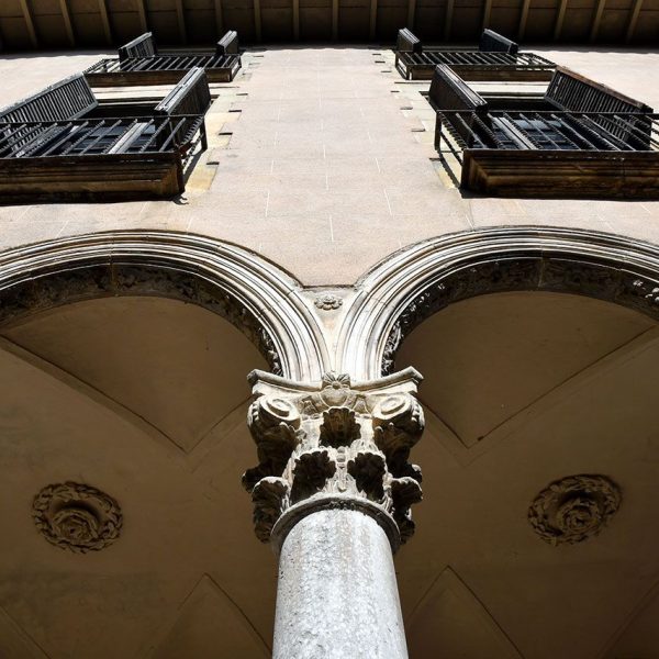 Vic.- Convent de Sant Domènec, S. XVII – Claustre quadrat amb galeries de sis arcs per banda dividits per dos units en el centre per una mena de capitell suspès al aire (6/2020)