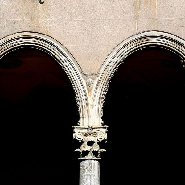 Vic.- Convent de Sant Domènec, S. XVII – Claustre quadrat amb galeries de sis arcs per banda dividits per dos units en el centre per una mena de capitell suspès al aire (6/2020)