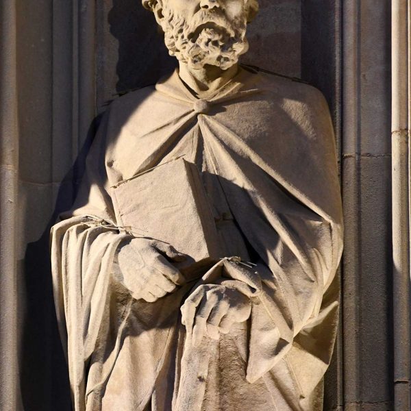 Barcelona.- Catedral gòtica de la Santa Creu i Santa Eulàlia, S. XIII/XV – Detall d’un dels apòstols que flanquegen la porta obra de l’escultor Agapit Vallmitjana (1/2026)