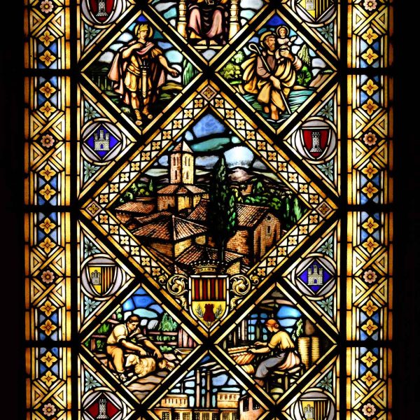 Terrassa.- Ajuntament neogòtic de l’any 1900-1903 – Finestra de l’escala de vitralls de colors centrada per les esglésies visigòtiques de Sant Pere (2/2026)