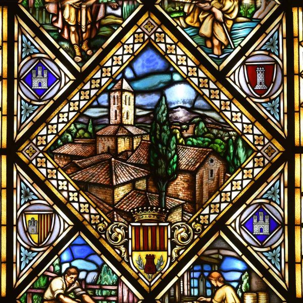Terrassa.- Ajuntament neogòtic de l’any 1900-1903 – Finestra de l’escala de vitralls de colors centrada per les esglésies visigòtiques de Sant Pere (2/2026)