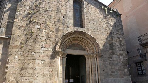 Barcelona.- Capella romànica de Santa Llúcia construïda entre 1557 i 1268 – Façana amb la portalada romànica d’arquivoltes coronada per un campanar d’espadanya de dos ulls (6/2015)