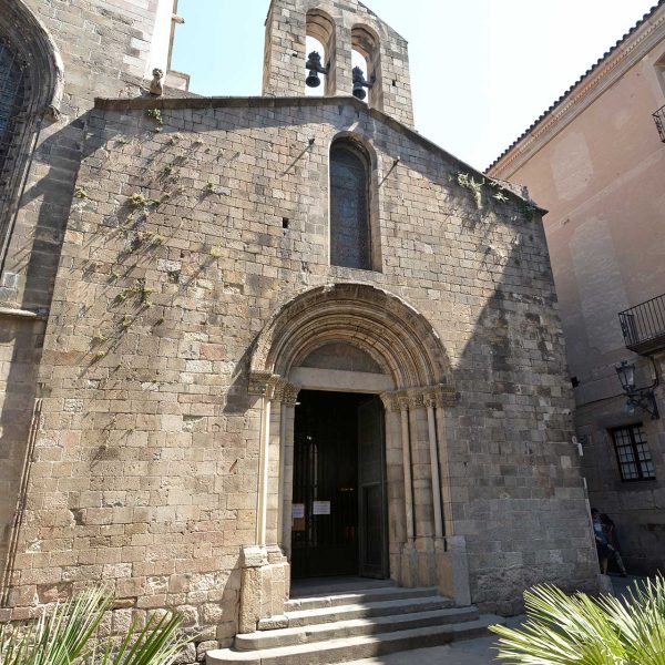 Barcelona.- Capella romànica de Santa Llúcia construïda entre 1557 i 1268 – Façana amb la portalada romànica d’arquivoltes coronada per un campanar d’espadanya de dos ulls (6/2015)