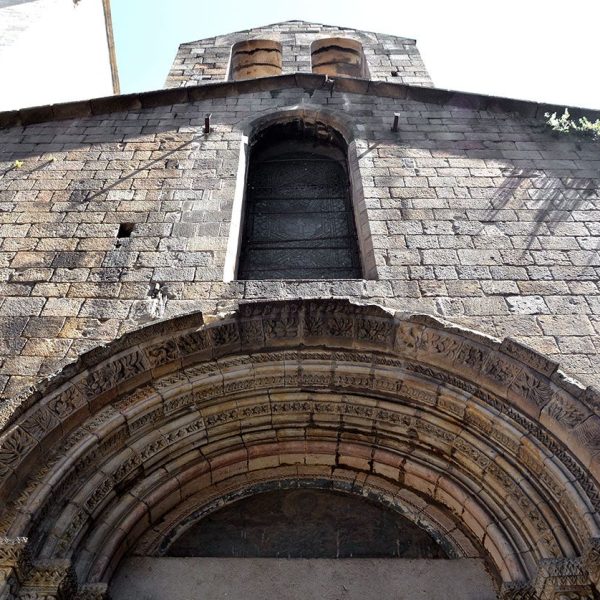Barcelona.- Capella romànica de Santa Llúcia construïda entre 1557 i 1268 – Façana amb la portalada romànica d’arquivoltes coronada per un campanar d’espadanya de dos ulls (5/2015)