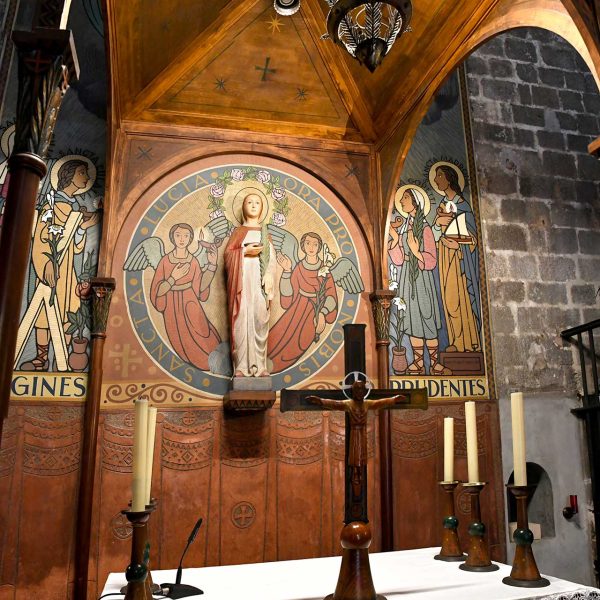 Barcelona.- Capella romànica de Santa Llúcia - Altar centrat per la imatge de Sta. Llúcia i les pintures laterals de Sta. Cecília, Sta. Eulàlia, Sta. Maria Gopetti i Sta. Madrona (3/2026)