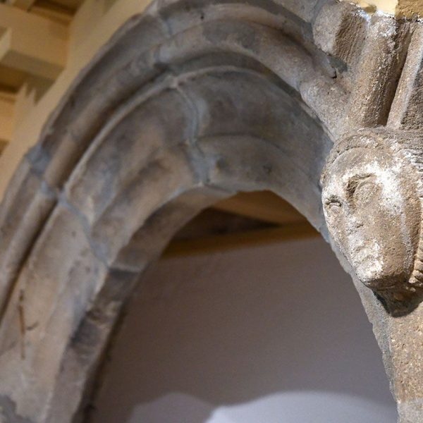 Terrassa.- Torre de Palau de l’antic castell – Detall d’una cara esculpida al capitell de les arcades del claustre exposat al Castell-Cartoixa de Vallparadís (3/2026)