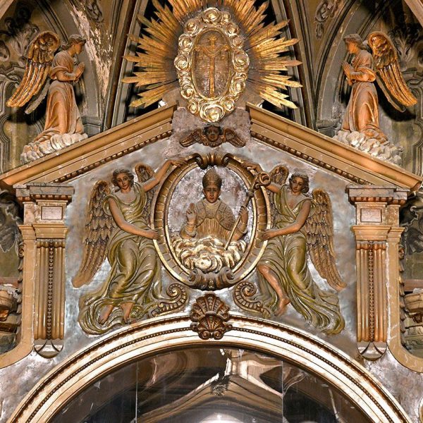 Vic.- Església barroca de la Pietat, S. XVI/XVII – Frontó triangular de l’arcada que comunica amb la capella dels Sants Màrtirs decorat amb relleus al·legòrics (8/2021)