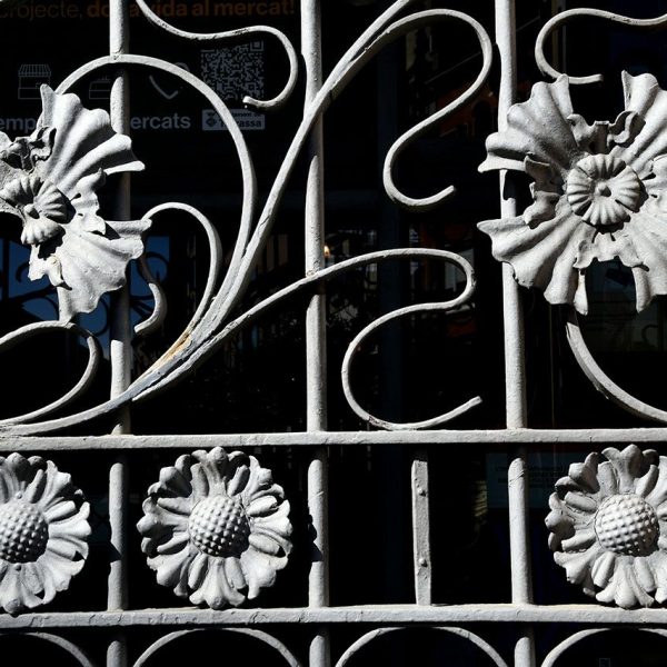 Terrassa.- Mercat de la Independència, d’estil modernista inaugurat el 1908 – Rosetes de ferro que decoren la reixa de la porta del Raval de Montserrat (3/2026)