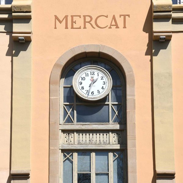 Terrassa.- Mercat de la Independència, d’estil modernista inaugurat el 1908 – Balcó del primer pis amb un rellotge sota l’arcada situat a la cantonada de la Rambla i carrer Goleta (3/2026)