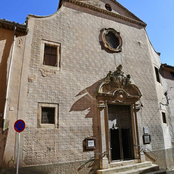Vic.- Església barroca dels Dolors, S. XVIII de Josep Morató – Façana amb un gran frontó trencat amb dos querubins assentats sostenint l’emblema del Sagrat Cor (2/2020)